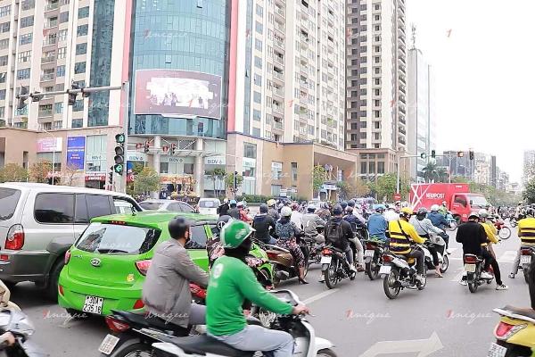 Màn hình LED quảng cáo ngoài trời tại một ngã tư đông đúc, hiển thị quảng cáo sản phẩm.