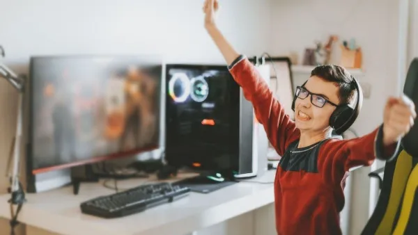 Laptop đặt trên bàn làm việc, màn hình hiển thị giao diện game hoặc phần mềm liên quan đến game.