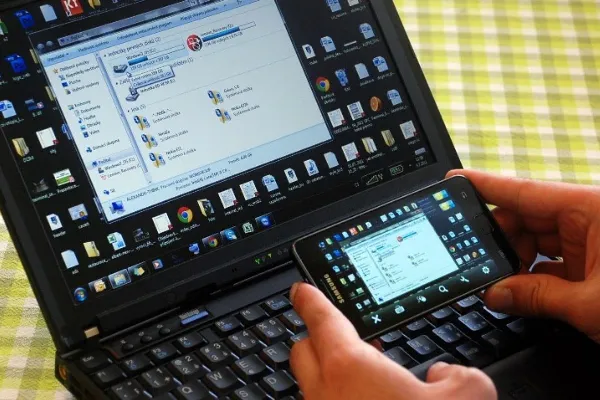 Người dùng điều khiển laptop từ xa bằng điện thoại để trình chiếu hoặc chia sẻ màn hình